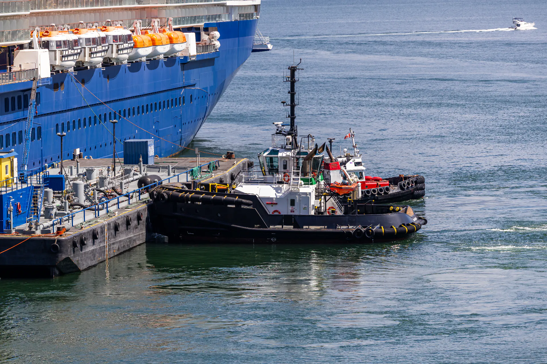 Tugs working alongside a large ship in port